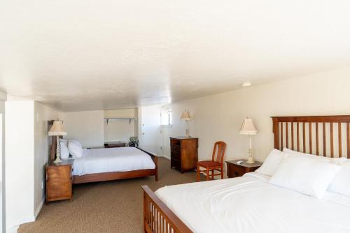 a hotel room with two beds and a chair at Road Creek Inn in Loa