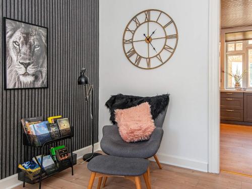a room with a chair and a clock on the wall at 4 star holiday home in Nørre Nebel in Nørre Nebel