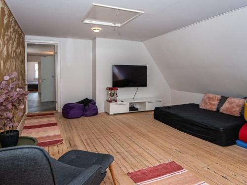 a living room with a couch and a flat screen tv at 4 star holiday home in Nørre Nebel in Nørre Nebel