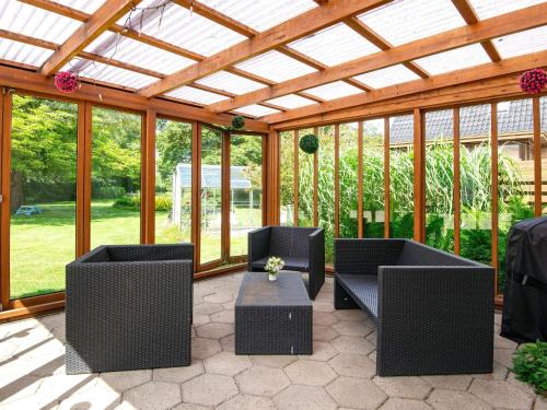 a screened in patio with two chairs and a table at 4 star holiday home in Nørre Nebel in Nørre Nebel