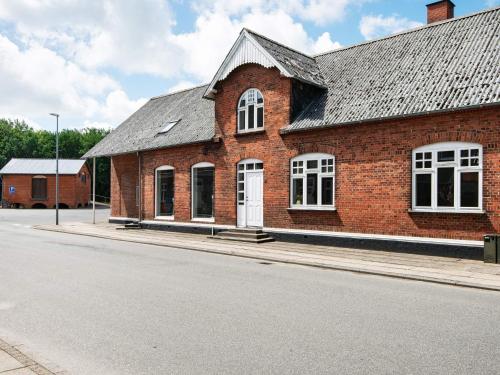 a brick building with a white door on a street at 4 star holiday home in Nørre Nebel in Nørre Nebel