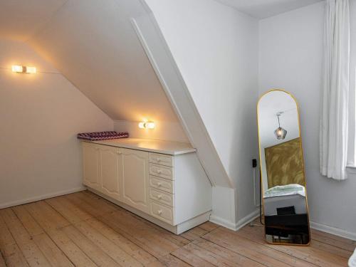a room with a dresser with a mirror and a staircase at 4 star holiday home in Nørre Nebel in Nørre Nebel