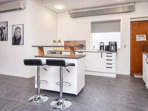 a kitchen with a counter and two bar stools at 4 star holiday home in Nørre Nebel in Nørre Nebel