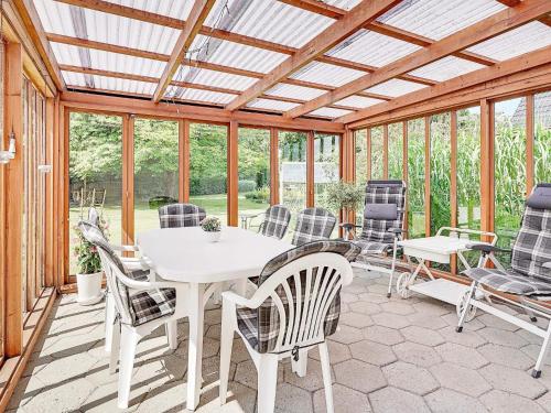a conservatory with a white table and chairs at 4 star holiday home in Nørre Nebel in Nørre Nebel