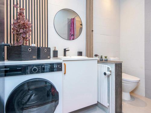a washing machine in a bathroom with a mirror at 4 star holiday home in Nørre Nebel in Nørre Nebel