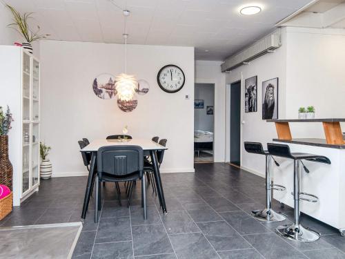 a room with a table and chairs and a clock at 4 star holiday home in Nørre Nebel in Nørre Nebel