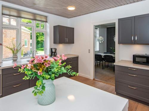 a kitchen with a vase of flowers on a counter at 4 star holiday home in Nørre Nebel in Nørre Nebel