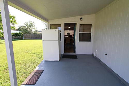 a white refrigerator on the porch of a house at The Peaceful One in Foley