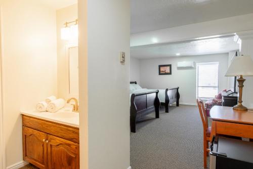 a bathroom with a sink and a bedroom with a bed at Road Creek Inn in Loa