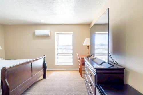 a bedroom with a bed and a dresser with a mirror at Road Creek Inn in Loa