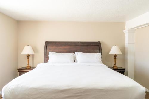a bedroom with a large white bed with two lamps at Road Creek Inn in Loa