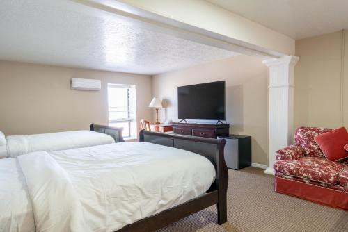 a bedroom with a bed and a tv and a chair at Road Creek Inn in Loa