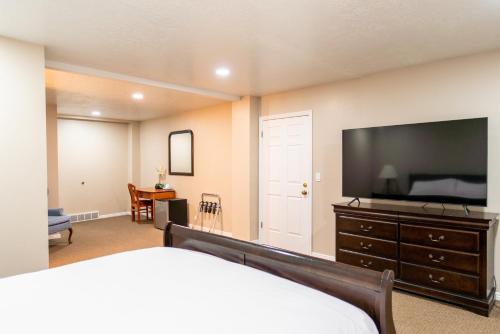 a bedroom with a bed and a flat screen tv at Road Creek Inn in Loa