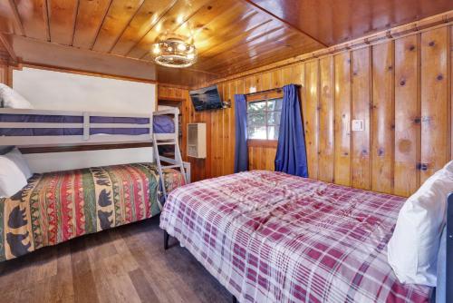 Un dormitorio con dos literas y paredes de madera. en Lakeview #104, en Big Bear Lake