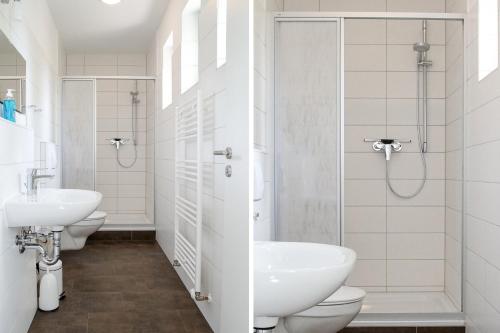 ein Badezimmer mit 2 Waschbecken und 2 WCs in der Unterkunft Apartmenthaus Eldena in Greifswald