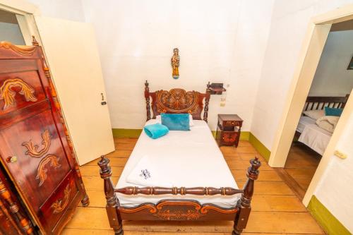a bedroom with a bed with blue pillows on it at Hotel Santa Laura Jerico in Jericó