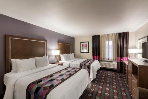 a hotel room with two beds and a television at Comfort Inn Tulsa Midtown in Tulsa