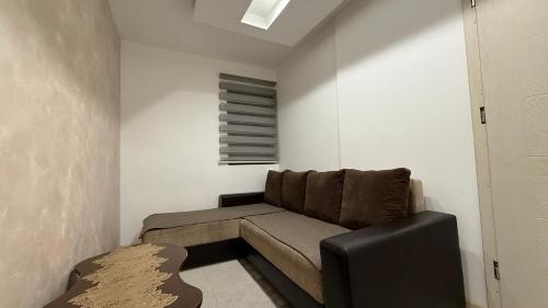 a small living room with a couch and a window at Vikendica Cerović in Kraljevo