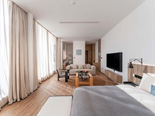 a living room with a bed and a couch at Jianglu Yalugu Hotel in Kaixuan