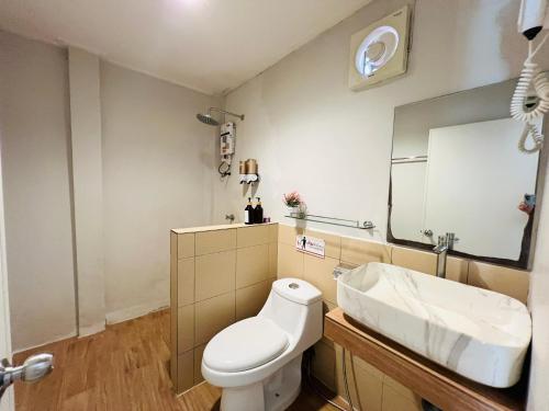 ein Badezimmer mit einer weißen Toilette und einem Waschbecken in der Unterkunft Maduel Resort Kohlarn in Ko Larn
