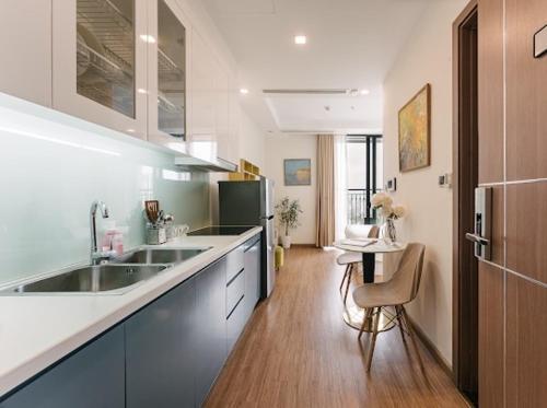 a large kitchen with a sink and a table at Luxury Studio With Swimming Pool, Gym And Tennis Courts In City Center in Hanoi