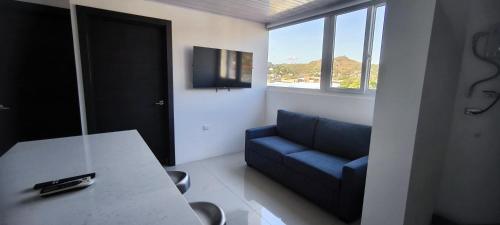 ein Wohnzimmer mit einem blauen Sofa und einem Tisch in der Unterkunft Apartamento en el centro de Matagalpa in Matagalpa
