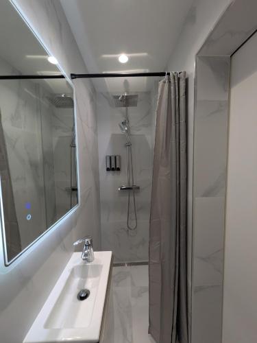 a white bathroom with a sink and a shower at Luxury studio Évry - Ris, 25 min to Paris in Ris-Orangis