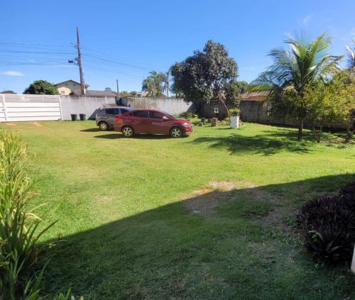 a yard with two cars parked in the grass at Flat Morada da Neblina! in Chapada dos Guimarães