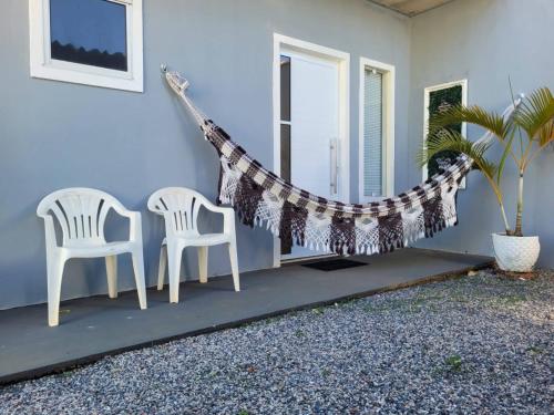 two chairs and a hammock on a porch at Flat Morada da Neblina! in Chapada dos Guimarães