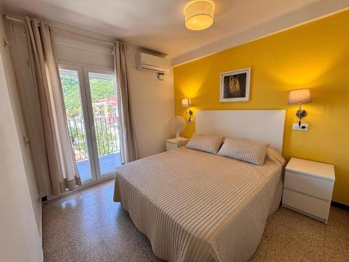 ein Schlafzimmer mit einem Bett und einer gelben Wand in der Unterkunft Grecia - L'Estartit, Centro - ES-323-88 in Torroella de Montgrí