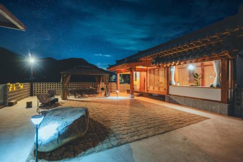 SayŏnにあるMilyang Soandangの夜のパティオに大きな岩がある家