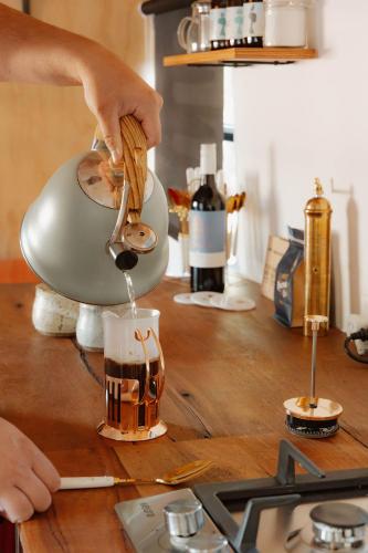 a person pouring liquid into a drink in a mixer at R&R Bus Retreat in Wellington Mills