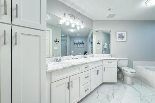 奥兰治比奇Charming 2bd/2ba w/ Bay View, Pool w/ Lazy River的带两个水槽和一个马桶的白色浴室