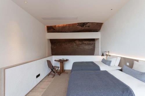 a bedroom with two beds and a small table at Jianglu Yalugu Hotel in Kaixuan