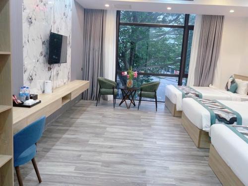 a hotel room with two beds and a television at SALA HOTEL MÓNG CÁI in Móng Cái
