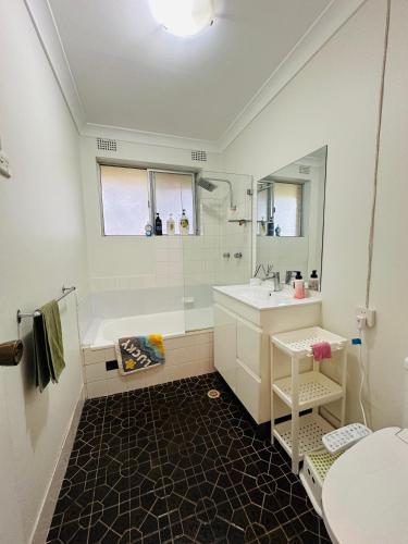 a bathroom with a white tub and a sink at Tranquil Retreat in Chatswood in Sydney