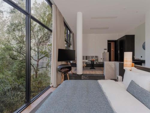 a bedroom with a large bed and a large window at Jianglu Yalugu Hotel in Kaixuan