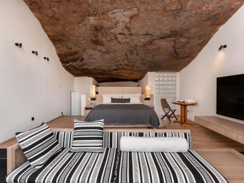 a bedroom with a large bed with a rock ceiling at Jianglu Yalugu Hotel in Kaixuan