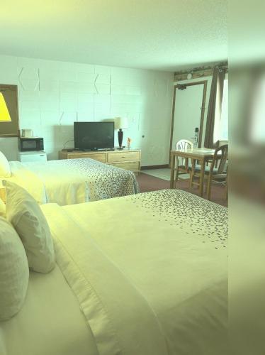 a hotel room with two beds and a table at Dakota Inn in Huron