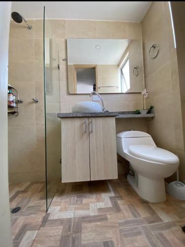 a bathroom with a toilet and a sink and a shower at Apartamento amoblado valle de Lili, Dolce Vita in Cali