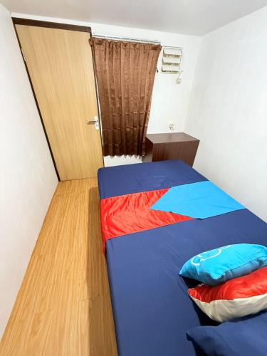 a small room with a bed and a door at Ambon Residence Syariah in Ambon