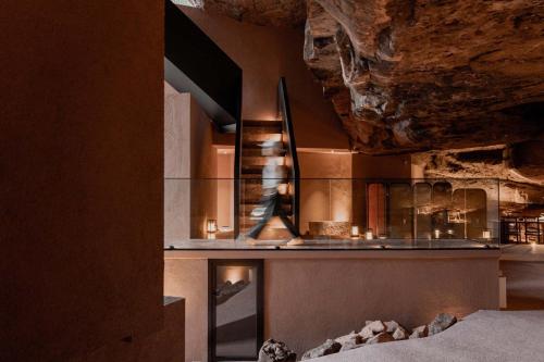 a person walking in a room with a rock wall at Jianglu Yalugu Hotel in Kaixuan