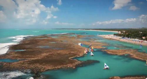 eine Insel mit zwei Booten im Wasser in der Unterkunft Apartamento Flat Porto de Galinhas - Piscinas Naturais in Porto De Galinhas