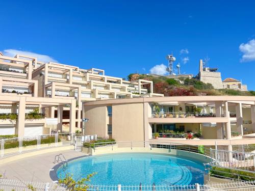 un immeuble avec une piscine devant un immeuble dans l'établissement Appartement 3 pièces, vue mer, parking, climatisation à Sète - FR-1-338-620, à Sète