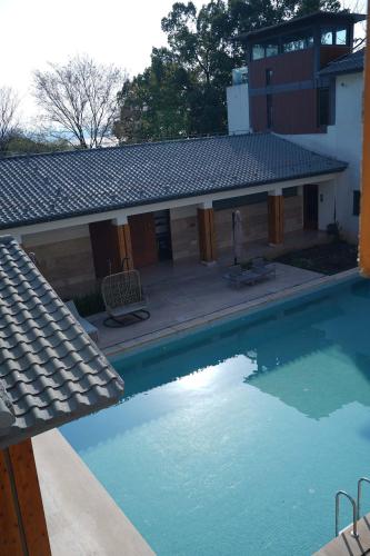 a swimming pool in front of a house at Meijie Xiuju in Xinchating