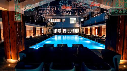 a large swimming pool with a table and chairs at Meijie Xiuju in Xinchating