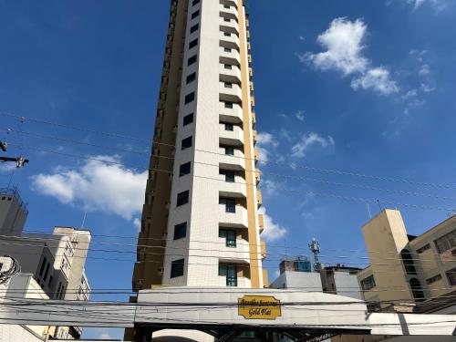 a tall white building with a sign in front of it at Flat Santana Próximo metrô UH 142 in Sao Paulo