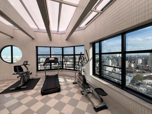a gym with treadmills and ellipticals in a room with windows at Flat Santana Próximo metrô UH 142 in Sao Paulo