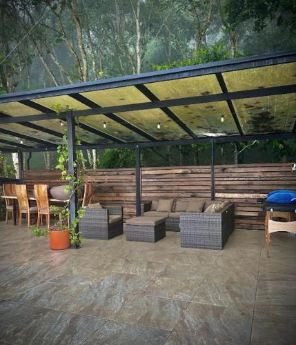 a patio with couches and chairs under a roof at Casa Fénix Zen Oasis Del Bosque in Calima