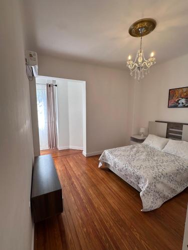 a bedroom with a bed and a chandelier at Amplio Apartamento de 4 dormitorios en el Centro de Montevideo in Montevideo